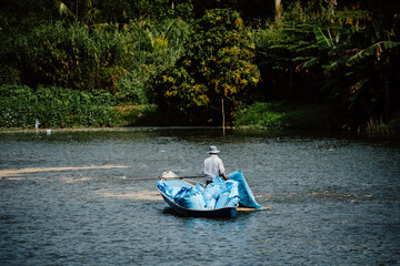 Man on a boat Feeding catfish in a large lake