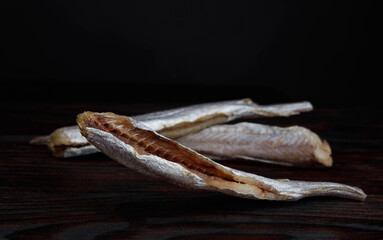 dried blue whiting , on a black background