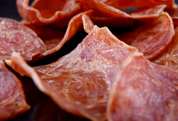 Meat chips lie on a wooden surface. Pieces of dried meat.