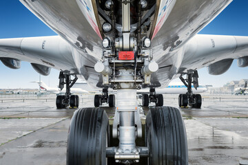 close view of landing gear under a big jet plane - obrazy, fototapety, plakaty