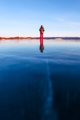 Girl walking on cracked ice of a frozen lake Baikal
