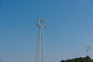 High voltage transmission tower on blue sky background
