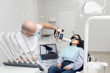 A dentist takes an X-ray of a patient. Snapshot of the jaw. Treatment in dentistry.
