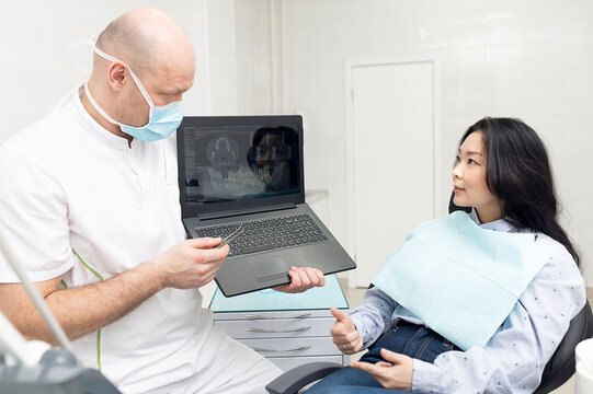 Dentist doctor and patient discussing looking at x-ray picture