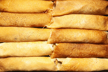 Fried and twisted pancakes stacked towards each other, top view.