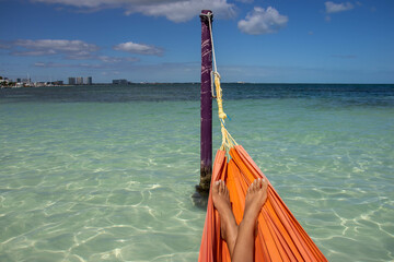 happy and comfortable feet of a woman in a hammock happily enjoying the paradise of the caribbean...
