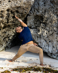 Asian man practicing variation of Virabhadrasana I. Warrior I Pose with twist. Yoga retreat....