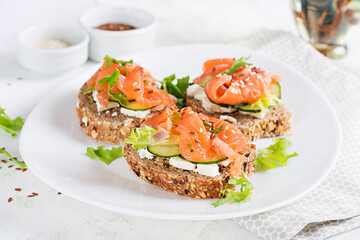 Open sandwiches with salted salmon, cheese cream and fresh cucumber. Seafood. Healthy food.