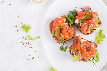 Open sandwiches with salted salmon, cheese cream and fresh cucumber. Seafood. Healthy food. Top view.