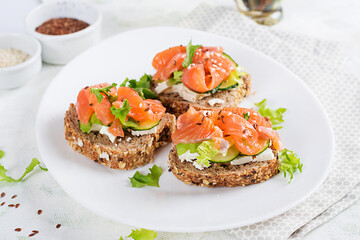 Open sandwiches with salted salmon, cheese cream and fresh cucumber. Seafood. Healthy food.