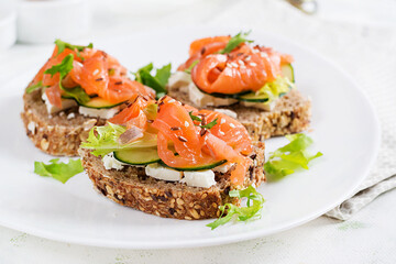 Open sandwiches with salted salmon, cheese cream and fresh cucumber. Seafood. Healthy food.