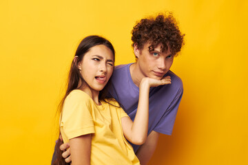 Naklejka premium cute young couple in colorful t-shirts posing friendship fun isolated background unaltered