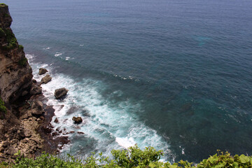 Wave, rocks, and ocean under Uluwatu Pura in Bali. Taken January 2022.
