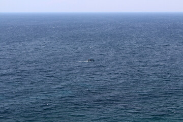 Small boat and horizon line of the Pacific ocean around Uluwatu. Taken January 2022.