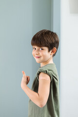 6 year old boy shows band aid on arm to confirm that he got vaccinated.
