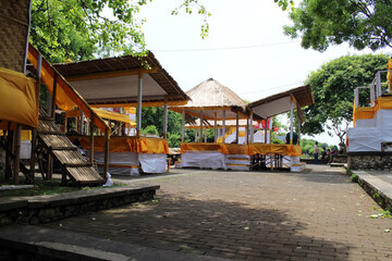 Temporary buildings covered by yellow clothes around Uluwatu Pura for ceremony.