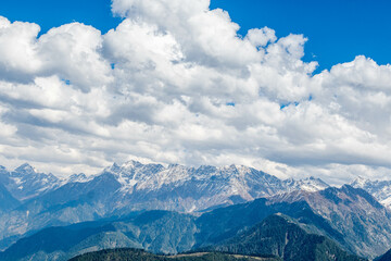 Fototapeta premium Blue Sky with full of White Clouds, and green trees, and the mountain is full of greeneries, a magical view of north Pakistan, Shogran National Park. 