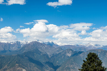 Obraz premium Blue Sky with full of White Clouds, and green trees, and the mountain is full of greeneries, a magical view of north Pakistan, Shogran National Park. 