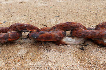 Old rusty chain on the beach sand
