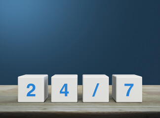 24/7 letter on white block cubes on wooden table over light blue wall, Business full time service concept