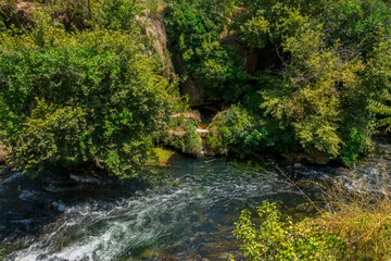 Summer landscape with big waterfall. Duden waterfalls in Antalya. River flowing through the trees.