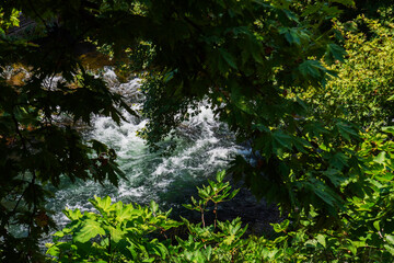 Summer landscape with big waterfall. Duden waterfalls in Antalya. River flowing through the trees.