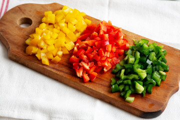 Chopped Fresh Colored Peppers on a Rustic Wooden Board, low angle view..