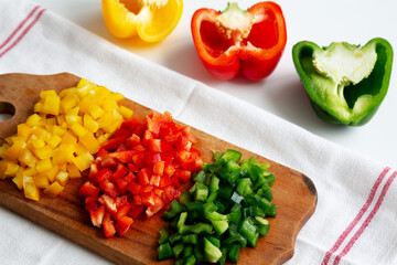 Chopped Fresh Colored Peppers on a Rustic Wooden Board, side view. Space for text.