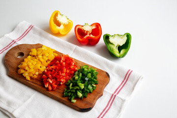 Chopped Fresh Colored Peppers on a Rustic Wooden Board, side view. Copy space..