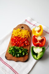 Chopped Fresh Colored Peppers on a Rustic Wooden Board, low angle view. Space for text.