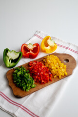 Chopped Fresh Colored Peppers on a Rustic Wooden Board, side view. Space for text.