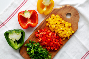 Chopped Fresh Colored Peppers on a Rustic Wooden Board, top view. Flat lay, overhead, from above.