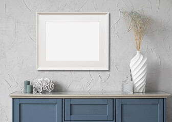 Blank picture frame mockup on gray wall. Artwork in minimal interior design. View of modern boho style interior with canvas for painting or poster on wall. Minimalism concept
