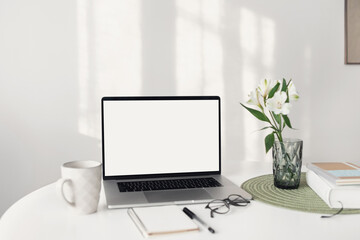 Laptop computer with empty blank mockup screen over white modern living room design. Home office, workplace, working or studying from home, distance learning, business concept