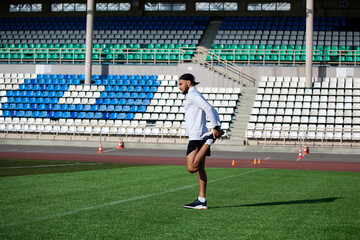 spotrsmen warming up before run on running track in stadium