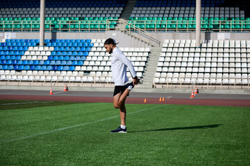 spotrsmen warming up before run on running track in stadium