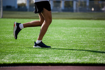 a white man in black shorts and white running at the stadium