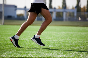 a white man in black shorts and white running at the stadium