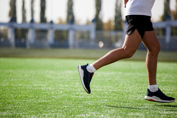 a white man in black shorts and white running at the stadium