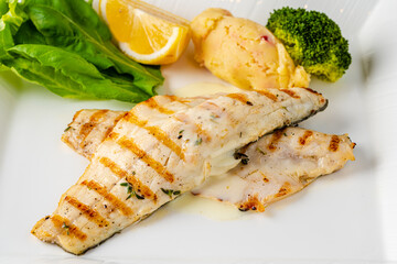 Grilled sea bass fillet served with garnishes in a fine dining restaurant