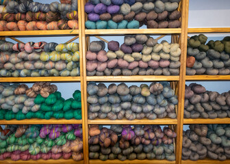 wool yarn threads, colored yarn skeins arranged on shelves, knitting as a hobby