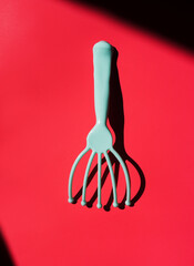 Blue massage tool at red background with shadow. Spa and wellness utensil for relaxing treatment....