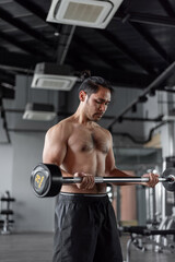 Fototapeta na wymiar Asian man exercises in fitness. Healthy man doing arms workout in fitness.