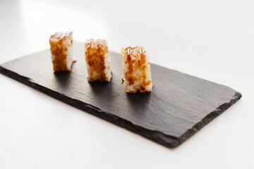 Sushi japan food on black plate at sushi restaurant or takeout with chopsticks on white. Delicious sushi japanese food with chopsticks fresh at the restaurant or takeout delivery.