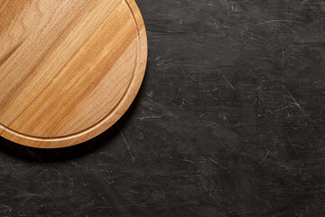 Pizza stand, round wooden, top view dark background, with space to copy text.