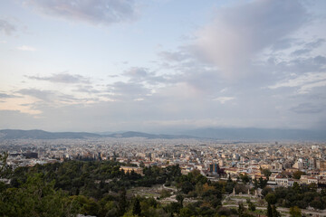 Fototapeta na wymiar View of the city of Athens November 17, 2021: Evening landscape, blue sky with clouds, soft light. Picturesque view from the hill to the old town.