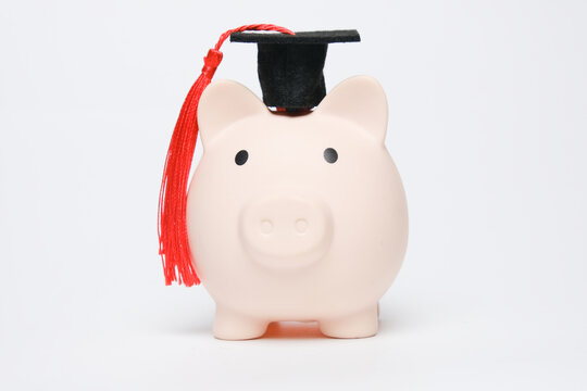 A picture of piggybank wearing mortar on white background. Education saving concept
