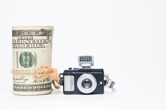 A picture of camera and fake money on white background. Make money with photography concept.