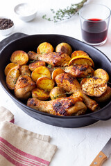 Baked chicken legs with potatoes and lemon. Recipe.