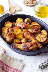 Baked chicken legs with potatoes and lemon. Recipe.